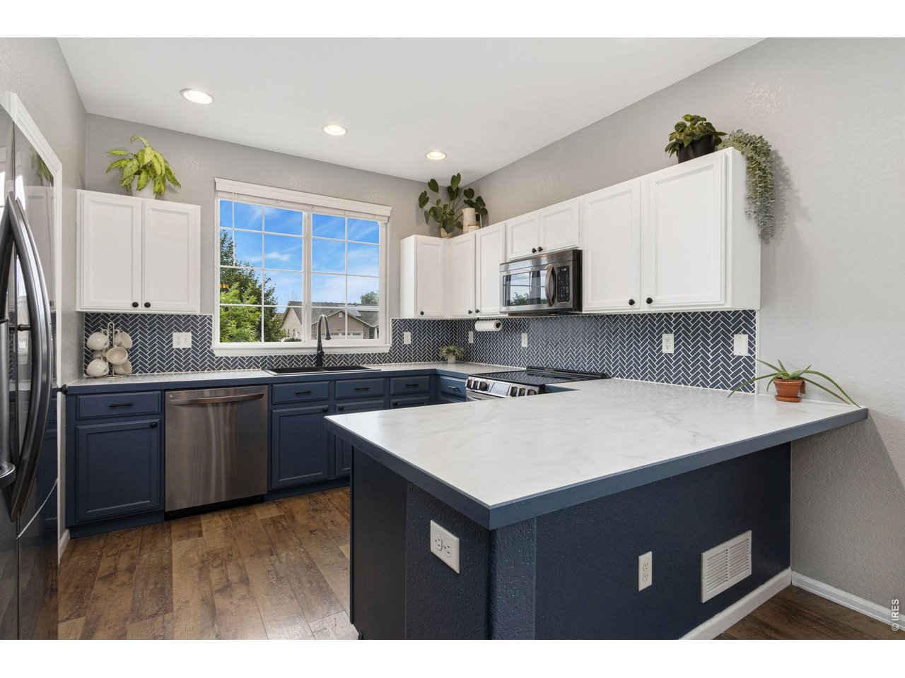 Property Photo 6 Crisp white uppers, rich blue lower cabinets, and a timeless backsplash give this kitchen both style and function.