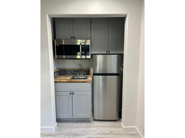 Property Photo 26 Kitchenette with sink, microwave and refrigerator. All appliances stay.