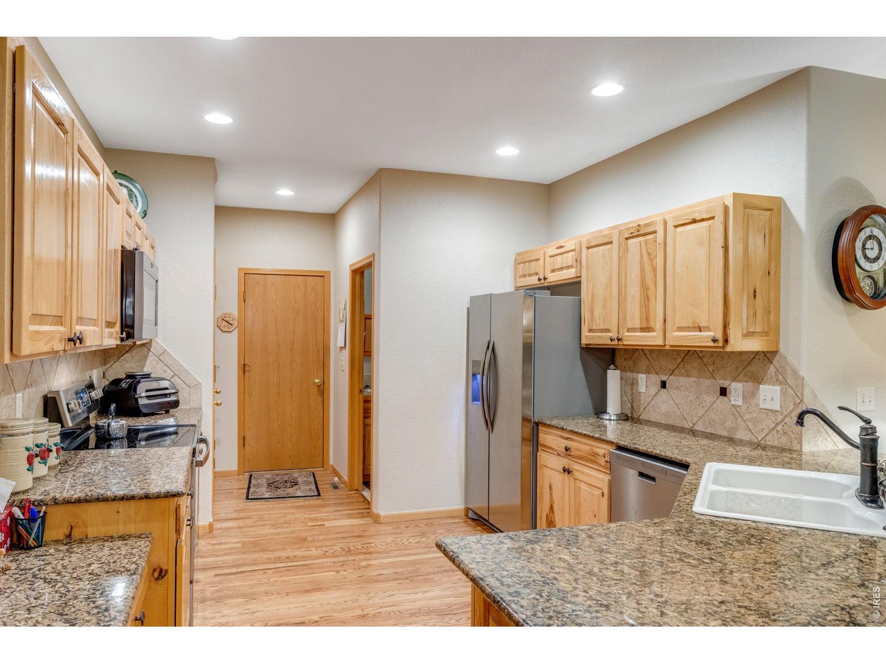 Property Photo 14 Kitchen is great for entertaining and features plenty of hickory cabinets with roll-out drawers and hardware, abundant granite slab countertop space, a full tile backsplash, breakfast bar, pantry, and all appliances are included