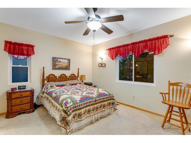 Property Photo 17 Primary bedroom with retreat, ceiling fan, walk-in closet, and a 5-piece bath featuring a corner soaking tub, two raised vanities, a full tile backsplash, and grab bars