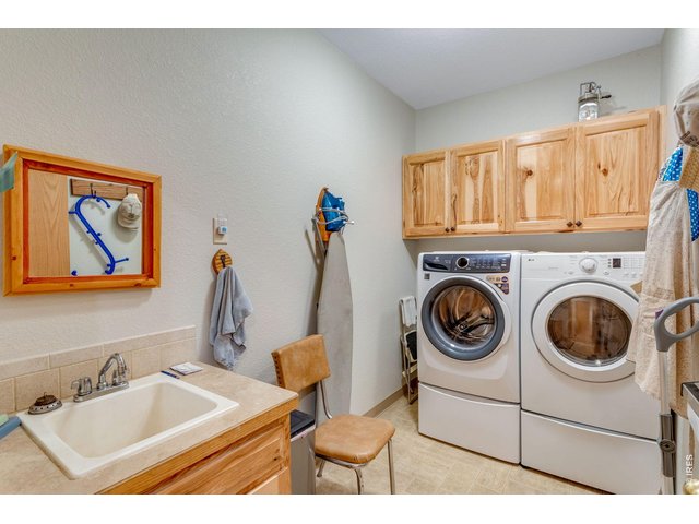 Property Photo 32 Laundry room off the garage featuring hickory cabinets and a utility sink