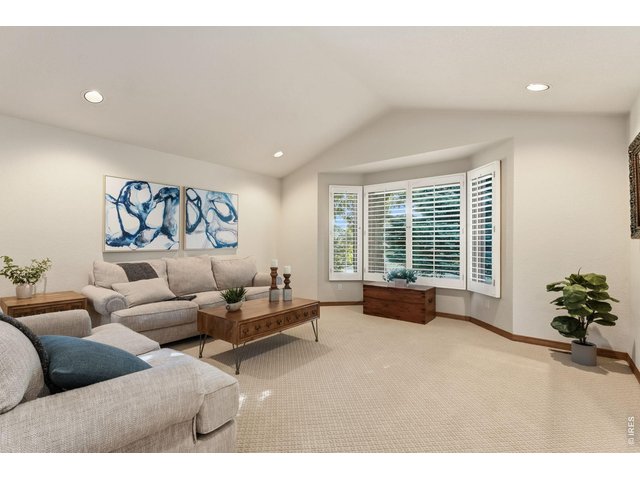 Property Photo 6 Natural light pours through the beautiful bay window, while custom plantation shutters offer a classic, upscale touch throughout the home.