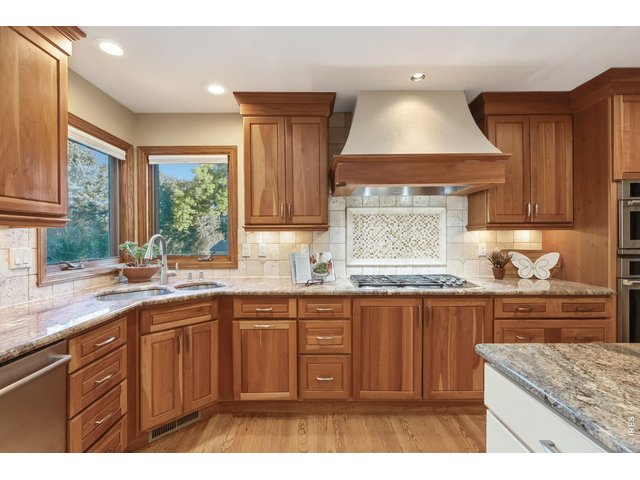 Property Photo 17 Rich cherry cabinetry, generous storage, and a custom range hood create a kitchen that's as beautiful as it is functional.