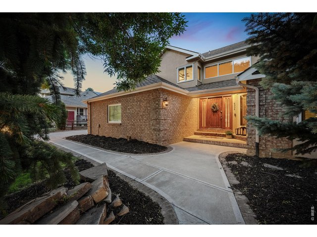 Property Photo 3 From the moment you arrive, the custom wood door creates a stunning first impression, inviting you inside, while timeless brick accents and soft evening lighting highlight the home's elegant curb appeal.