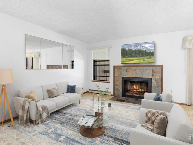 Property Photo 4 The inviting great room features a wood-burning slate fireplace, creating the perfect setting to relax after a day exploring Rocky Mountain National Park or downtown Estes Park