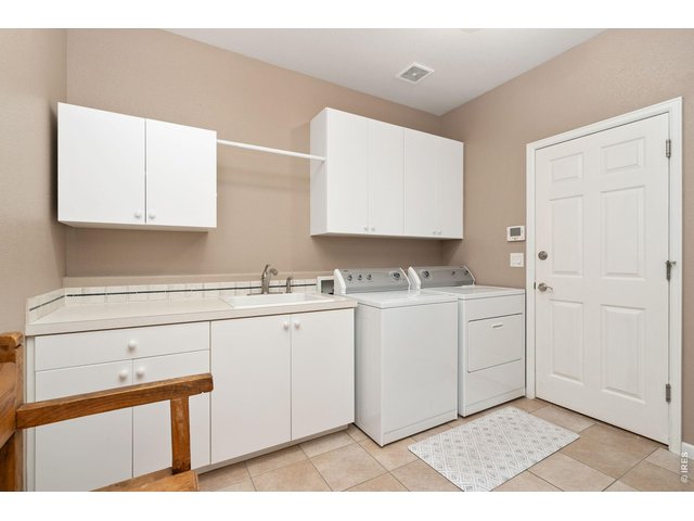 Property Photo 15 Huge laundry off garage into kitchen with counter, cabinets, and sink.