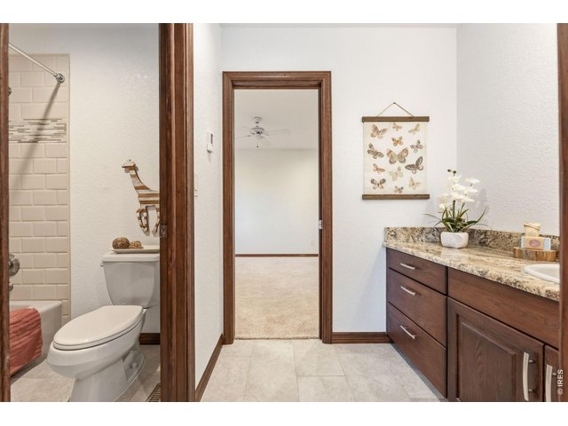 Property Photo 30 Thoughtfully designed Jack & Jill bathroom featuring granite countertops and rich cabinetry.