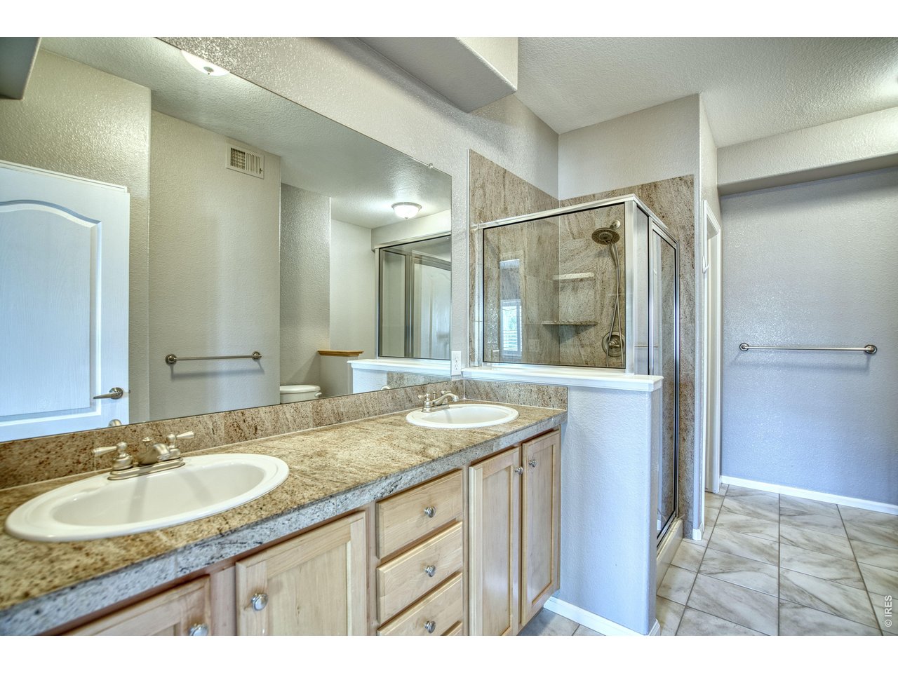 Property Photo 23 5-piece primary bath highlights luxury features with double sinks & shower stall.