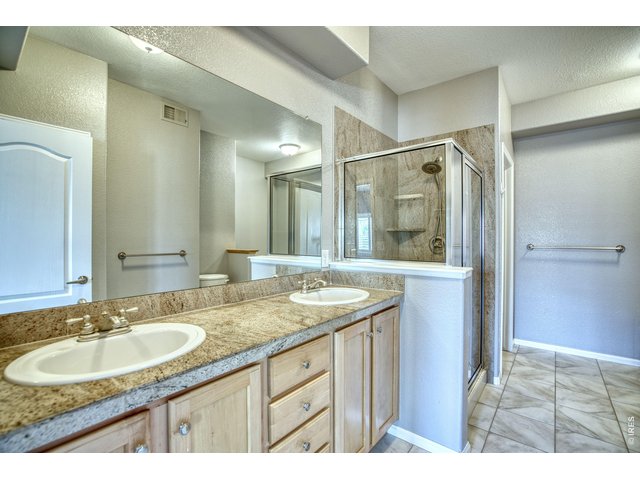 Property Photo 23 5-piece primary bath highlights luxury features with double sinks & shower stall.