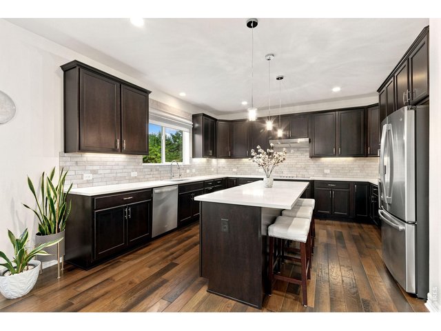 Property Photo 16 Spacious eat in kitchen with quartz counter tops, chocolate cabinets, beautiful backsplash and large island.
