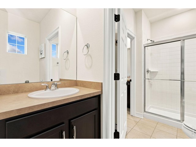 Property Photo 31 Upstairs bathroom pairs with second and third bedrooms. Dual sinks and step in shower.