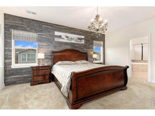 Property Photo 24 Upstairs Primary bedroom offers a beautiful chandelier, roman shades and custom wall decor.