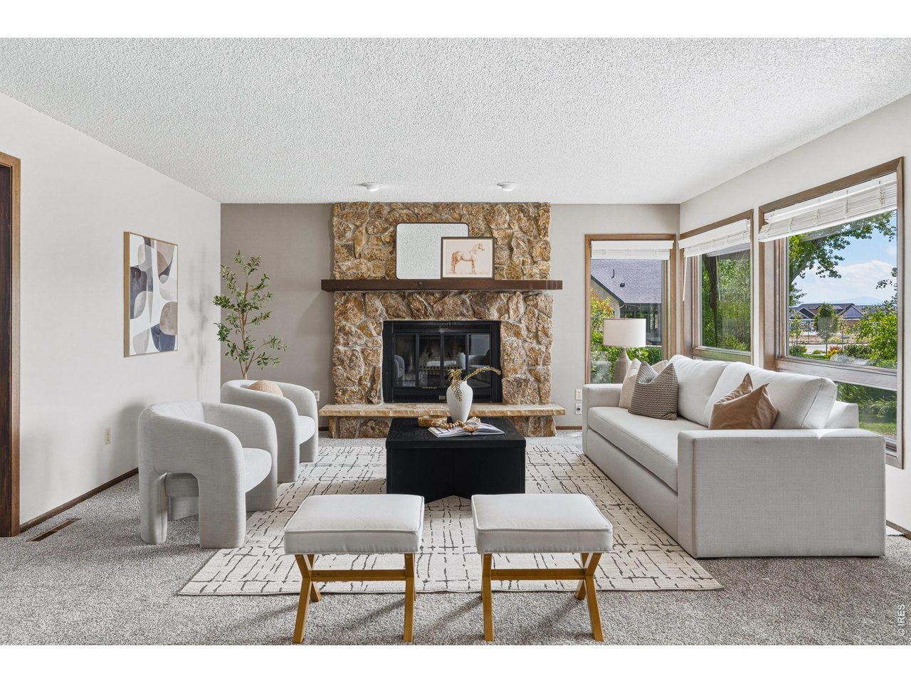 Property Photo 4 Light-filled living room anchored by a beautiful stone fireplace.