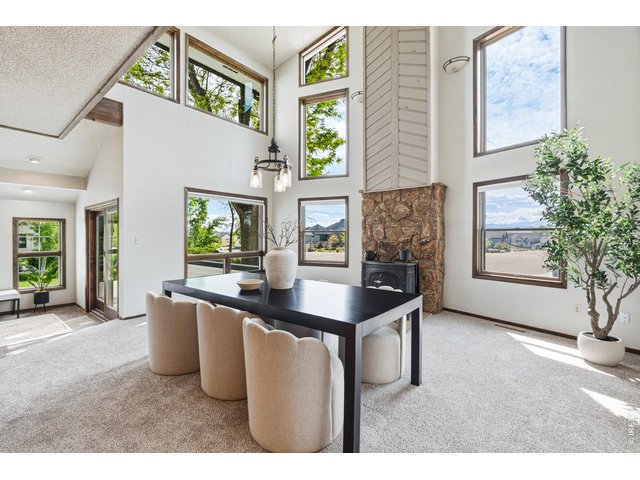 Property Photo 6 Dining space anchored by vaulted ceilings and wood-burning stove for added warmth and charm.