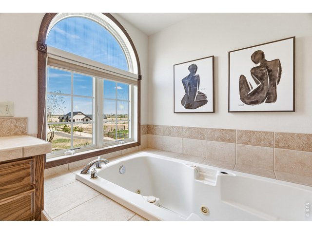 Property Photo 25 Soaking tub positioned beneath arched window-bringing in natural light and elevated charm.