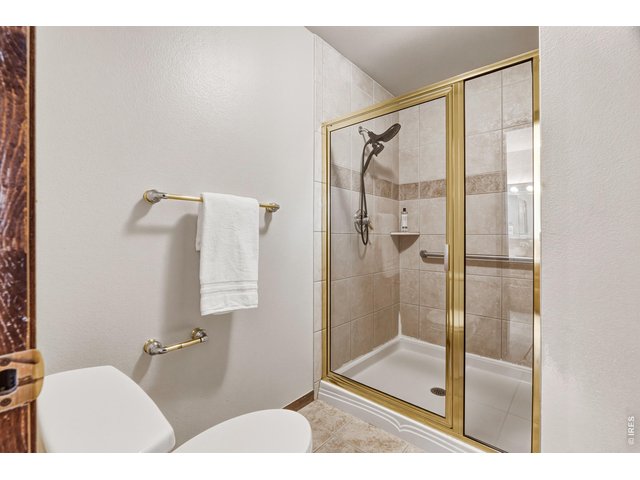Property Photo 26 Primary shower with glass enclosure and tile surround.