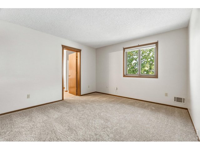 Property Photo 31 Light-filled bedroom with corner windows and treetop views.