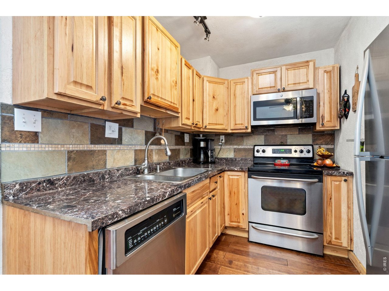 Property Photo 6 Updated kitchen with stainless appliances including a nearly new refrigerator. Hardwood cabinets!