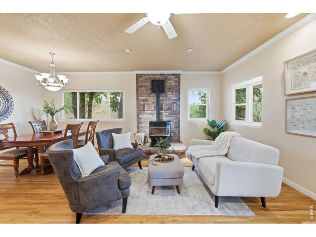 Property Photo 10 A brick hearth and pellet stove anchor the living room, with windows on three sides.