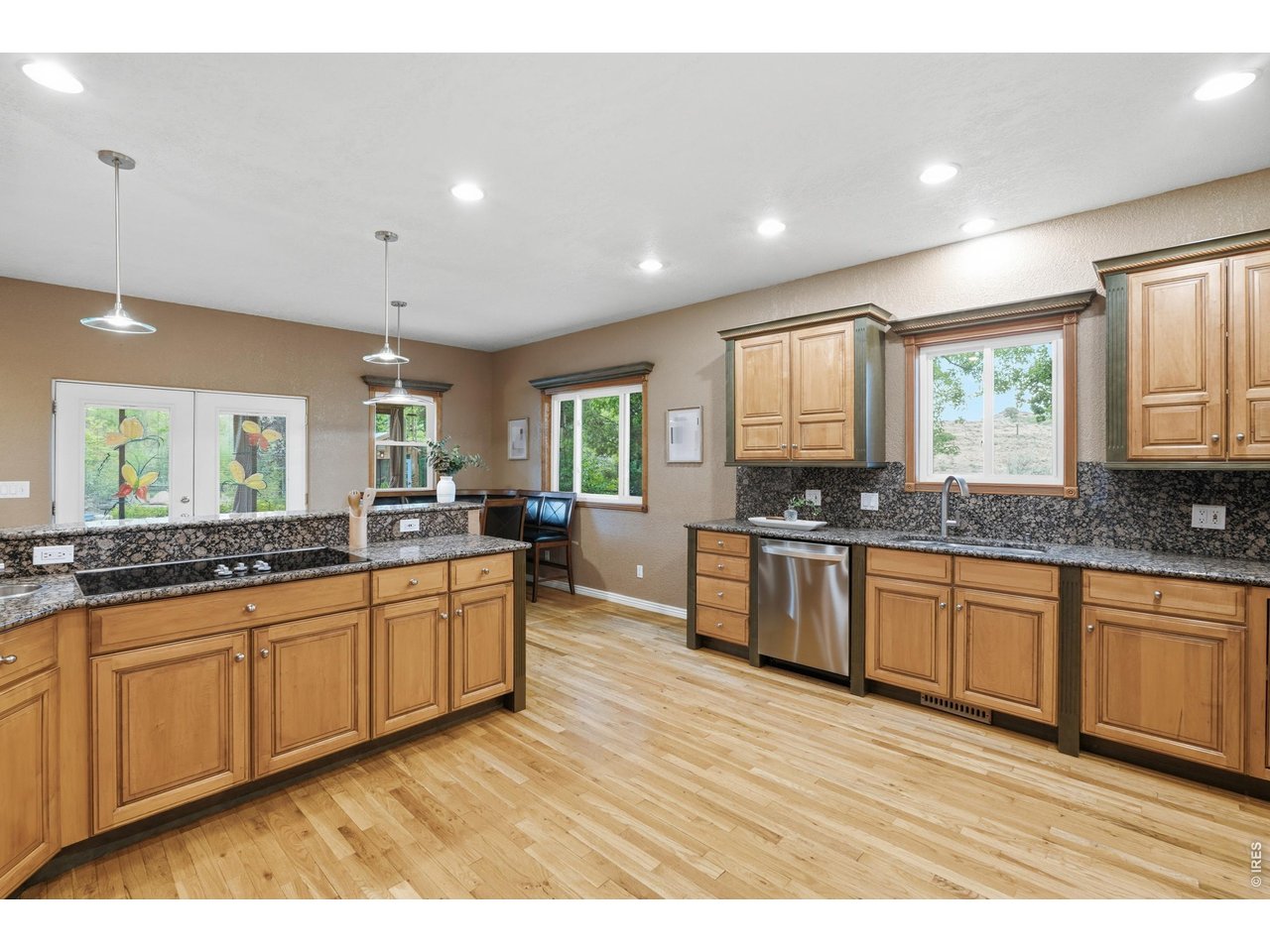 Property Photo 13 Granite counters, hardwood floors, and generous cabinetry in the kitchen.