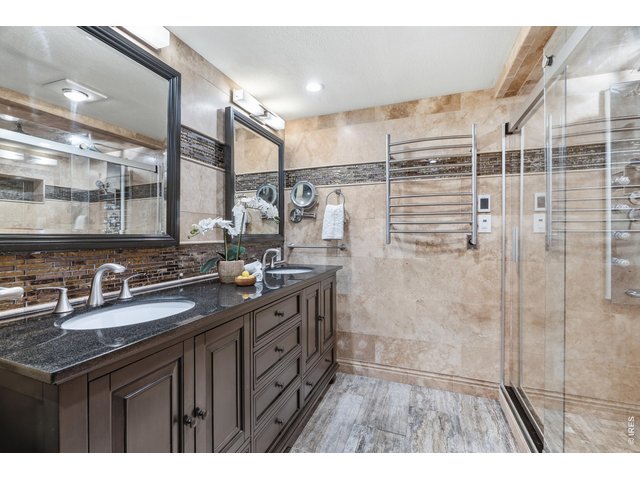 Property Photo 20 Upgraded primary bath double vanity, heated towel bars and flooring, and a dual-head glass shower.