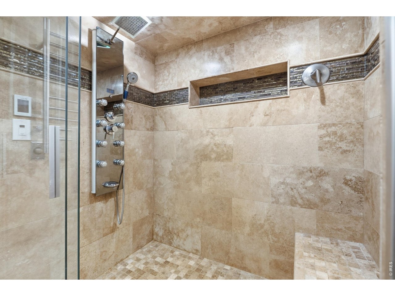 Property Photo 21 Travertine surround, rain head, and a multi-jet shower panel in the primary bath.