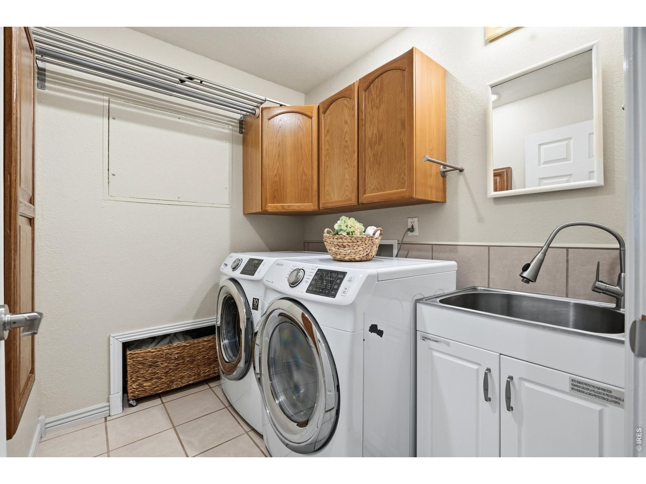 Property Photo 27 Dedicated laundry room with utility sink, hanging rod, and extra cabinetry.