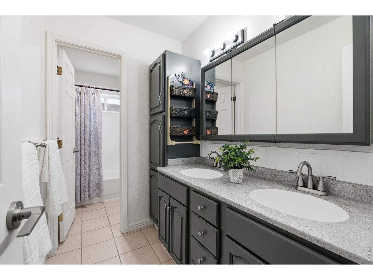 Property Photo 30 Second full bath on upper level with double vanity, linen tower, and separate tub and shower area.