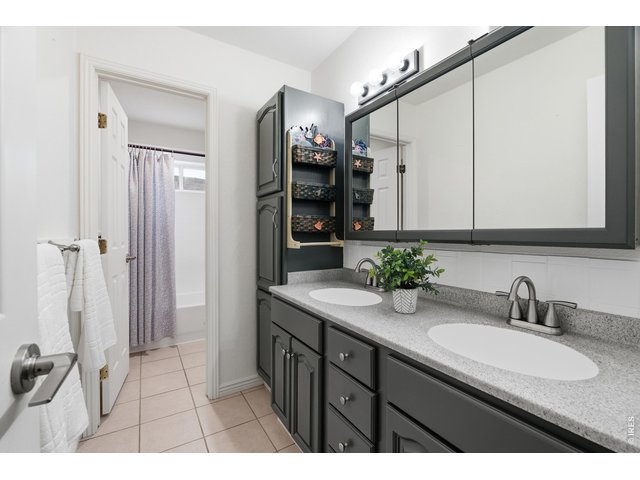 Property Photo 30 Second full bath on upper level with double vanity, linen tower, and separate tub and shower area.