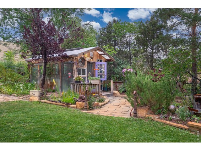 Property Photo 38 A custom greenhouse anchors the garden, reached by a flagstone path.