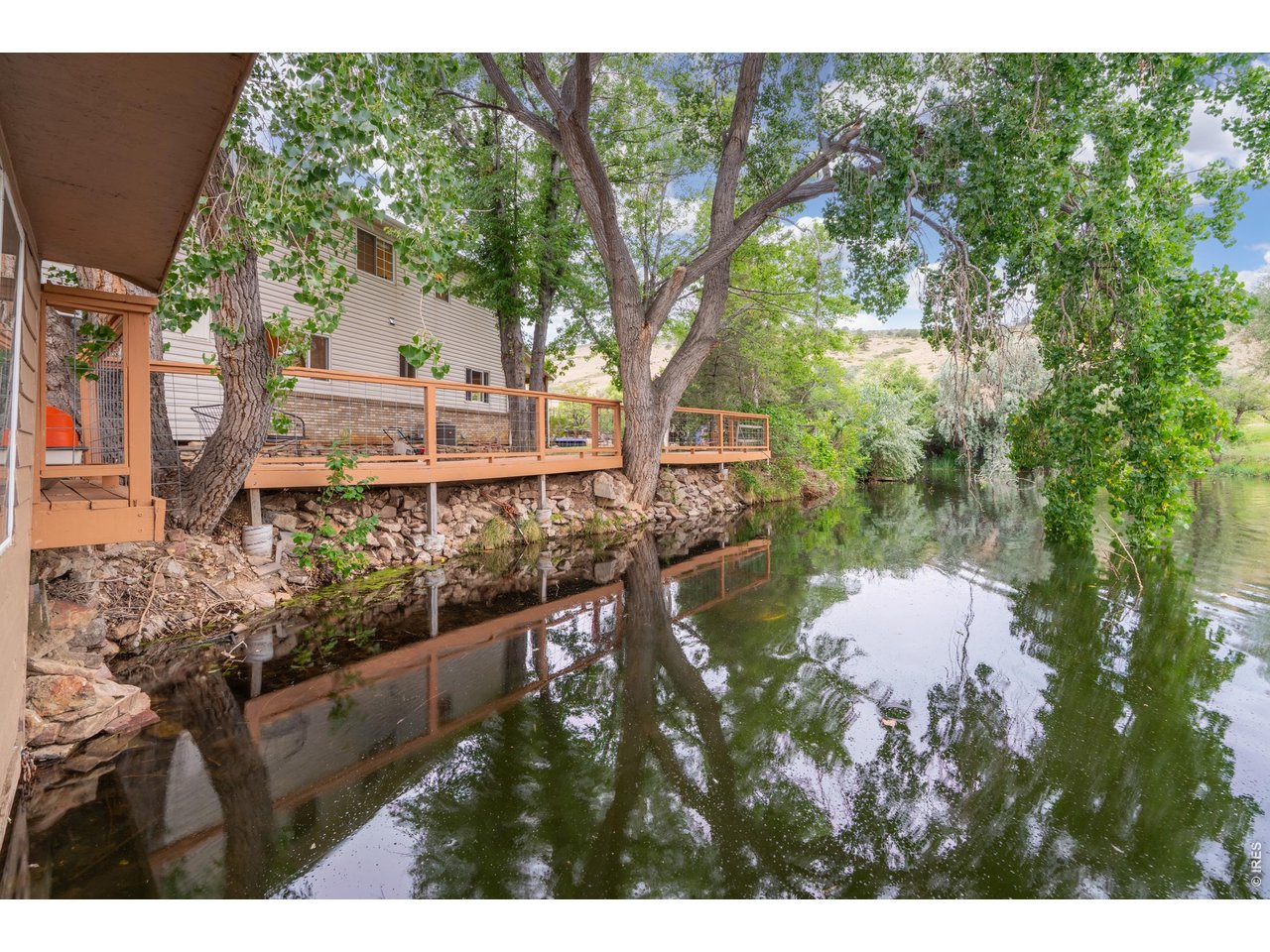 Property Photo 43 The deck runs to the water's edge along a rock-lined bank.
