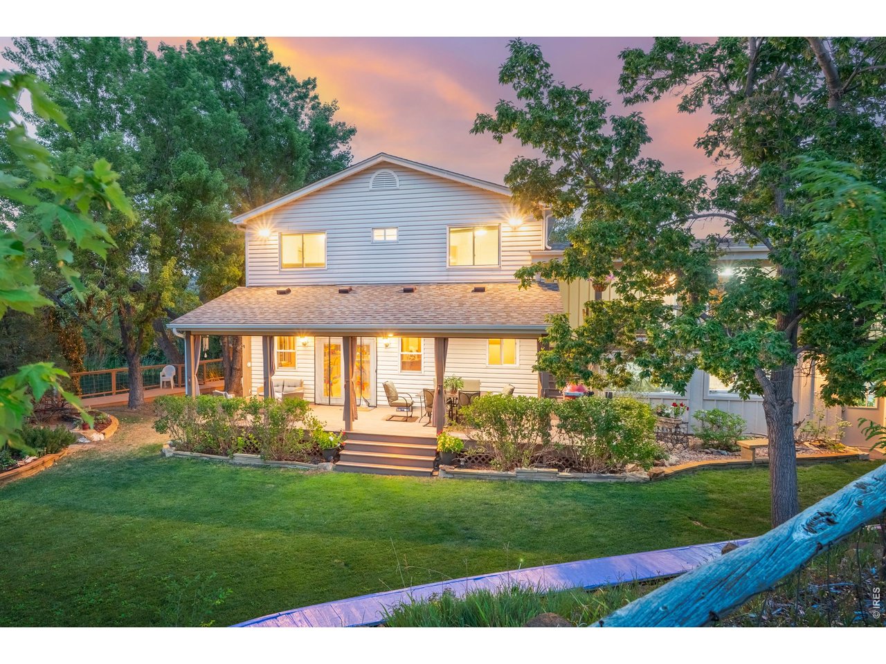 Property Photo 2 The back of the home at twilight, opening to the covered deck and lawn.