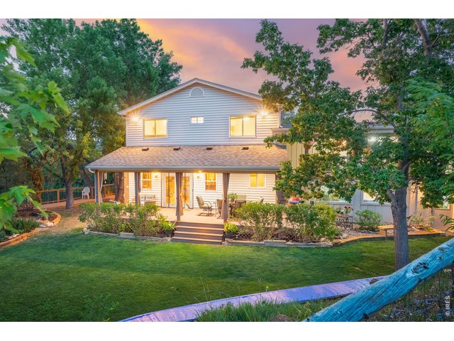 Property Photo 2 The back of the home at twilight, opening to the covered deck and lawn.