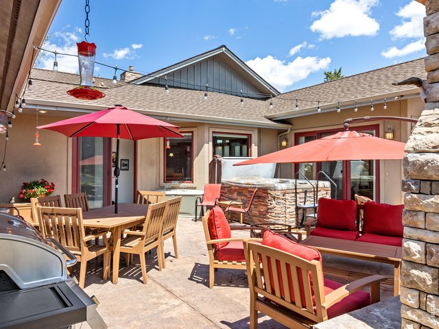 Property Photo 6 A stunning private courtyard welcomes you with a massive stone outdoor fireplace, relaxing hot tub, and beautiful stone accents, creating the perfect setting for year-round entertaining or peaceful evenings beneath the stars.