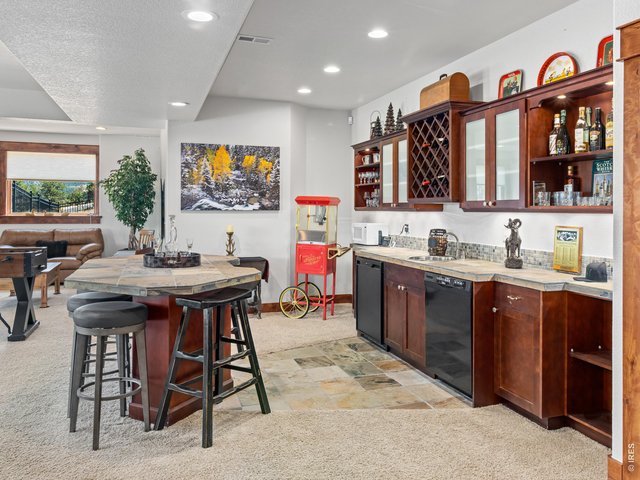 Property Photo 36 The expansive walk out lower level offers the ultimate space for entertaining, featuring a spacious family room with wet bar, game area, two additional bedrooms, and one-and-a-half bathrooms.