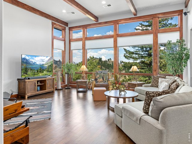 Property Photo 9 Soaring 12-foot ceilings and dramatic walls of windows fill the home with natural light while framing breathtaking mountain views.