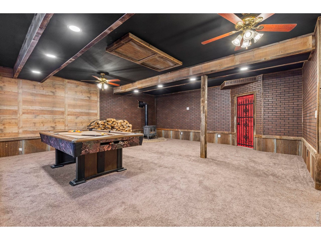 Property Photo 22 finished basement with included pool table and wood stove.