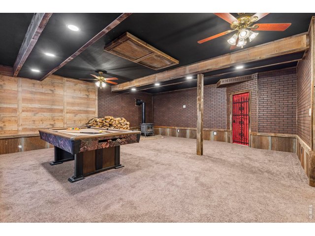 Property Photo 22 finished basement with included pool table and wood stove.