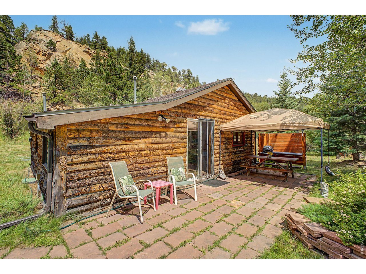 Property Photo 21 Main cabin with large flag stone patio, picnic table and shade steps to the river.