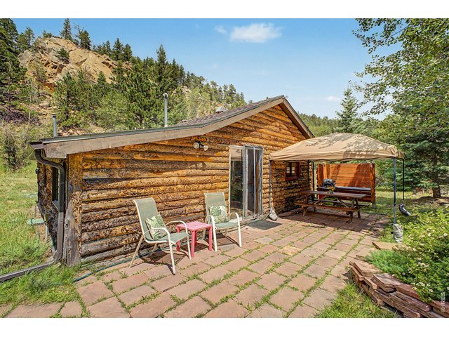 Property Photo 21 Main cabin with large flag stone patio, picnic table and shade steps to the river.