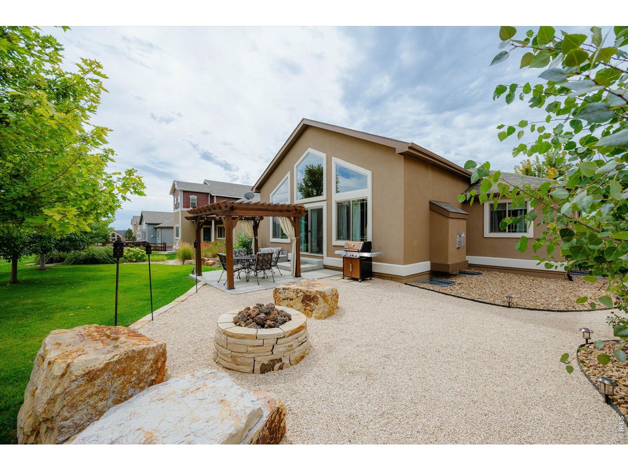 Property Photo 3 Stucco Home with Large Windows-Custom Landscape with Large Boulders for Sitting Around the Gas Fire Pit!