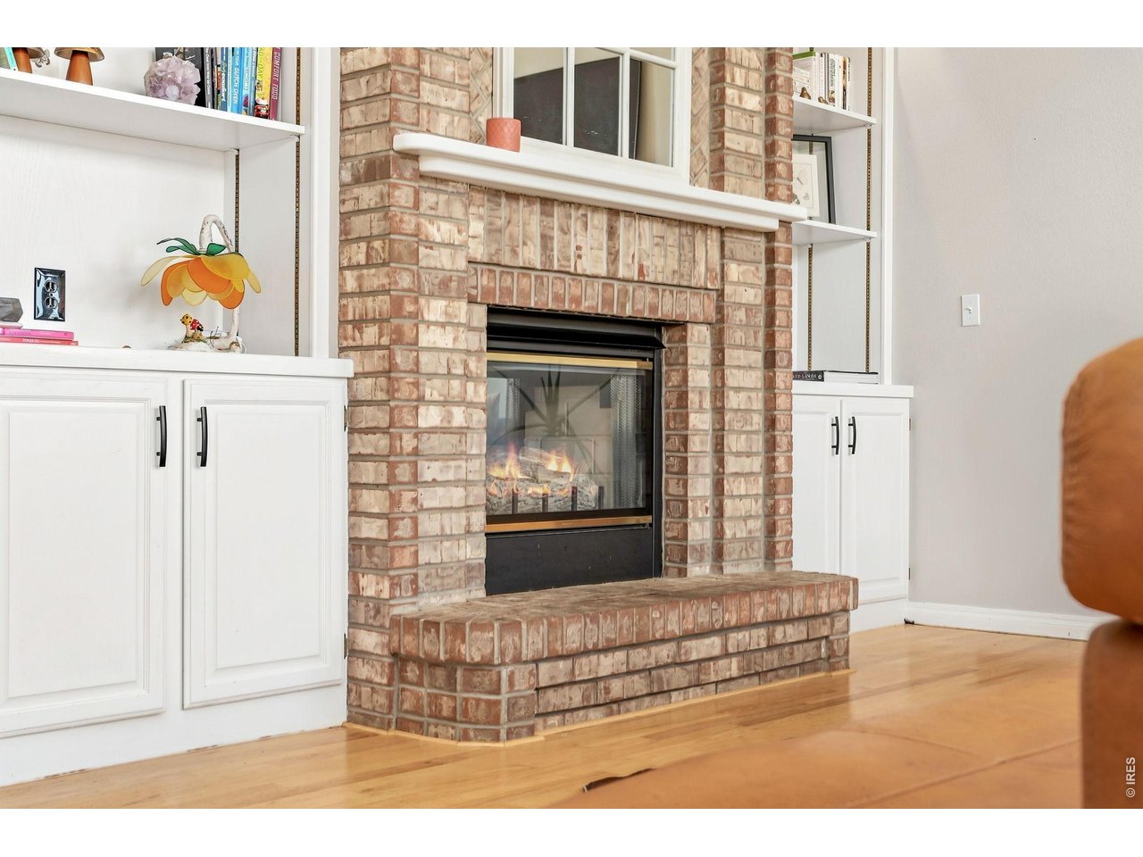 Property Photo 12 Built-in shelving surrounds the brick fireplace in family room.