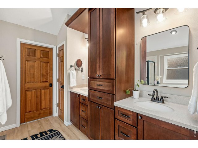 Property Photo 23 Custom cabinetry with dual vanities in en-suite primary bathroom.