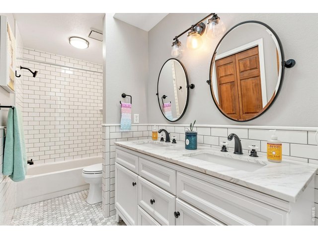 Property Photo 29 Updated secondary bathroom on upper level with dual sinks and tile finishes.