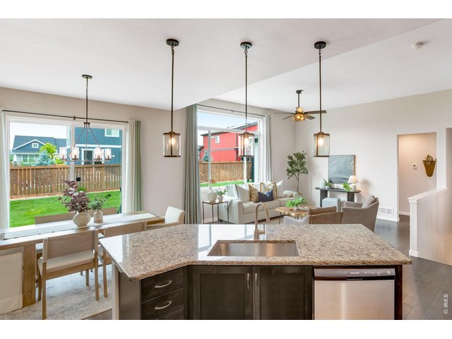 Property Photo 8 Expansive picture windows, oversized Granite island, pretty shaker style cabinetry. Bright and sunny, open concept easy living nearly 1,600 sqft on the main level.