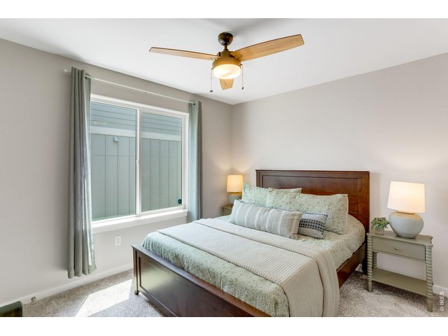 Property Photo 22 Secondary Bedroom on the main level, large picture windows, all window treatments included and all bedrooms on the main level have ceiling fans.