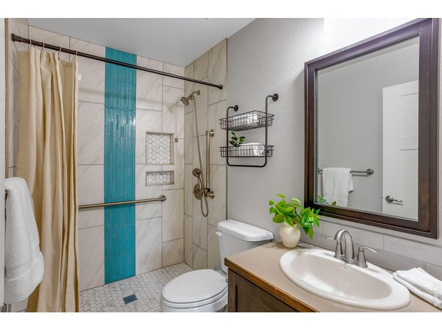 Property Photo 23 Main Level 3/4 Bathroom beautifully customized and upgraded - tile to the ceiling and a custom poured pan tile floor.