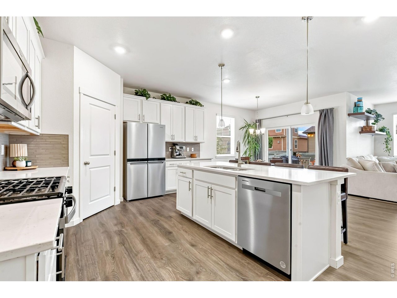 Property Photo 5 Beautiful kitchen features stainless steel appliances, gas range/oven, quartz countertops, and pantry.