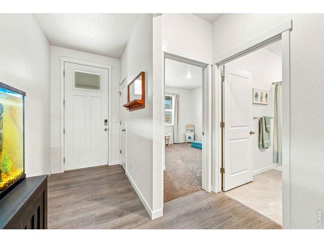Property Photo 16 Front door entry opens to long hallway with secondary bedrooms and a full bathroom.