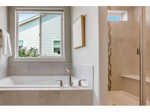 Property Photo 20 Oversized shower with beautiful custom tile work and cool down seat and soaking tub.